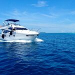 white and blue yacht on sea under blue sky during daytime