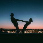 silhouette of man jumping on the field during night time