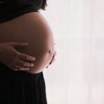 pregnant woman cradling her belly
