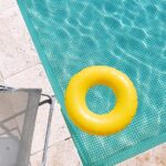 yellow pool float on swimming pool edge