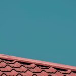 Close-up of red roof tiles with a clear blue sky background, offering ample copy space.