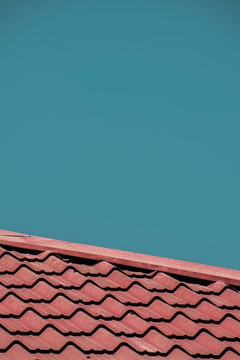 Close-up of red roof tiles with a clear blue sky background, offering ample copy space.