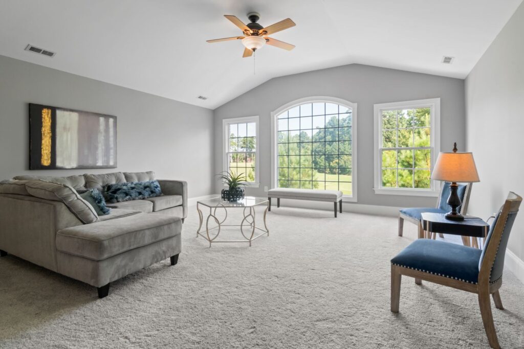 Contemporary living room with neutral tones, large windows, and modern furniture.