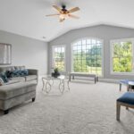 Contemporary living room with neutral tones, large windows, and modern furniture.