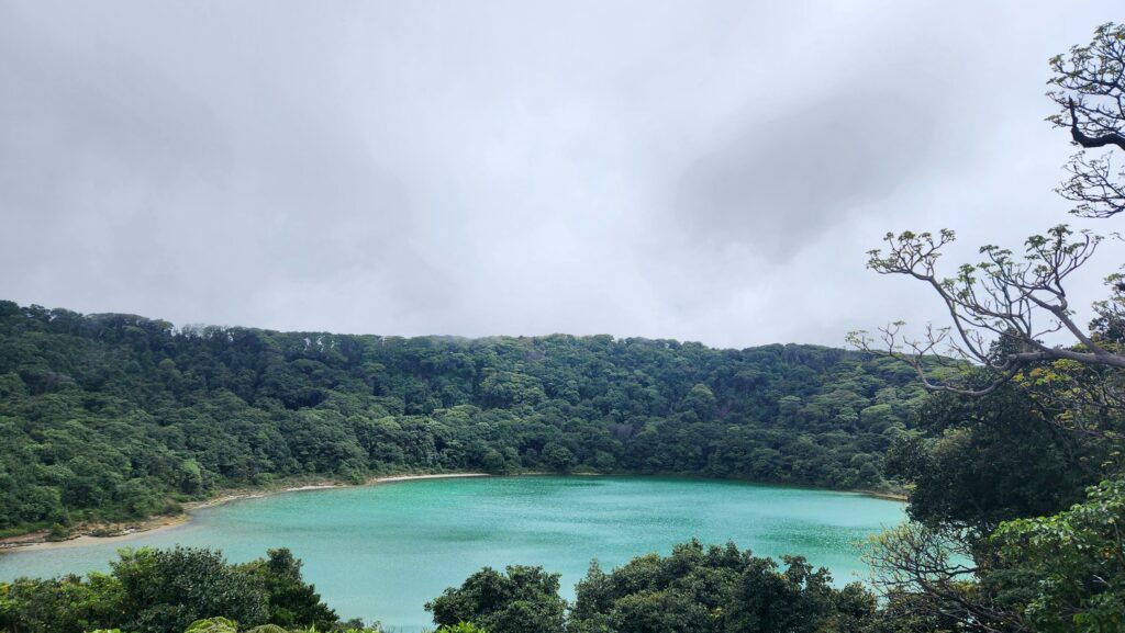 Turquoise Laguna Botos crater lake surrounded by greenery