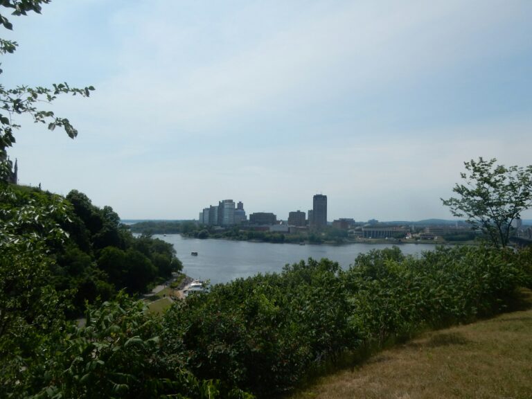 Ottawa River and Gatineau skyline viewed through green trees