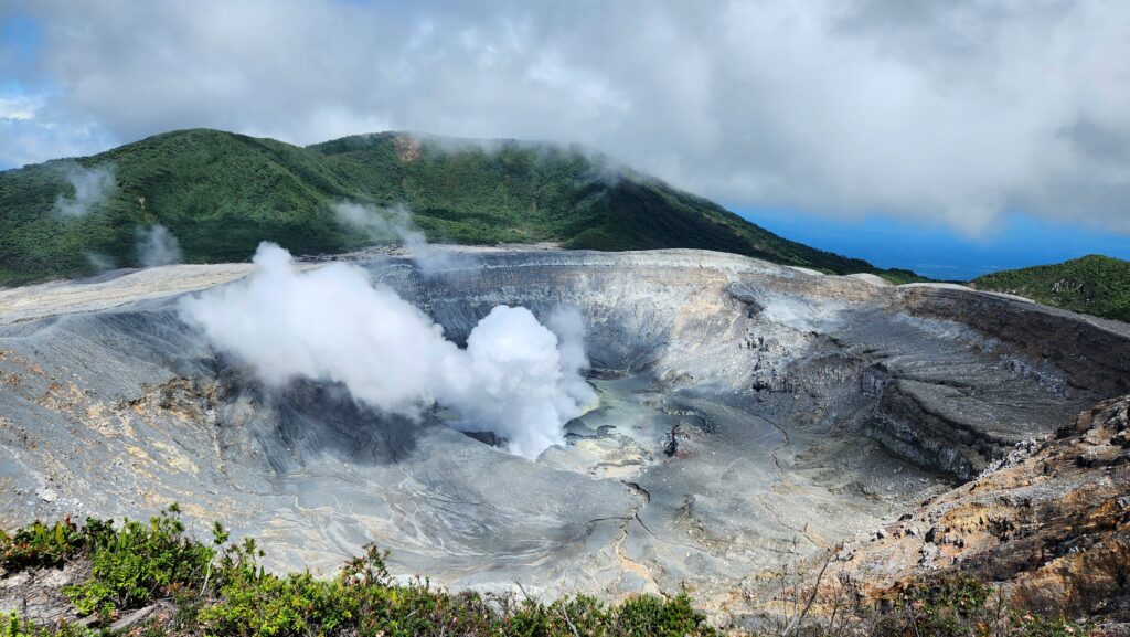 Poás main crater lake with gaseous emissions on a clear sunny day