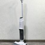 A floor sweeper sitting on top of a hard wood floor