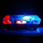 A police light bar flashing red and blue against a dark night background