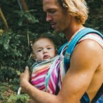 woman in blue tank top carrying baby in pink and white stripe shirt