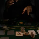a person sitting at a table with cards and chips