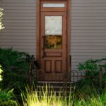 A wooden door with glass panels and plants