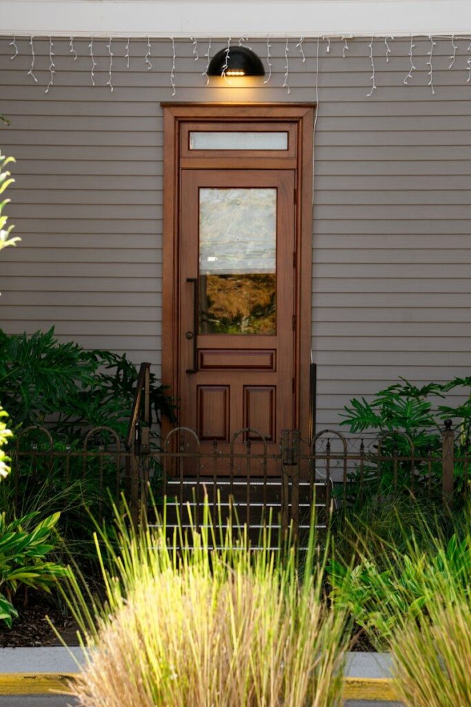 A wooden door with glass panels and plants
