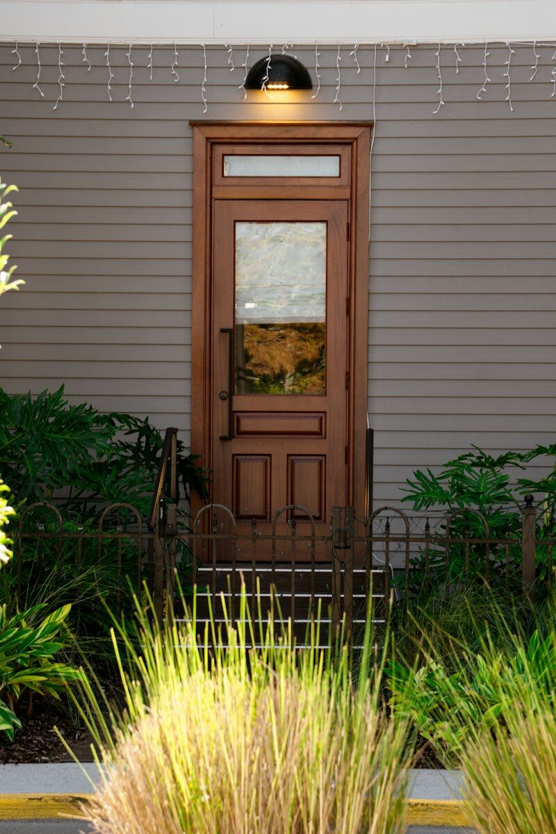 A wooden door with glass panels and plants