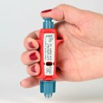 a hand holding a small bottle of nail polish