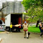 People unloading furniture from a moving truck outdoors