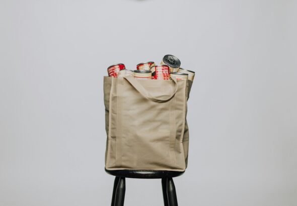 red labeled cans on white fabric handbag
