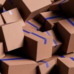 A large pile of brown cardboard boxes with blue tape