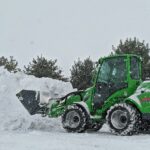 green and black atv on snow covered ground